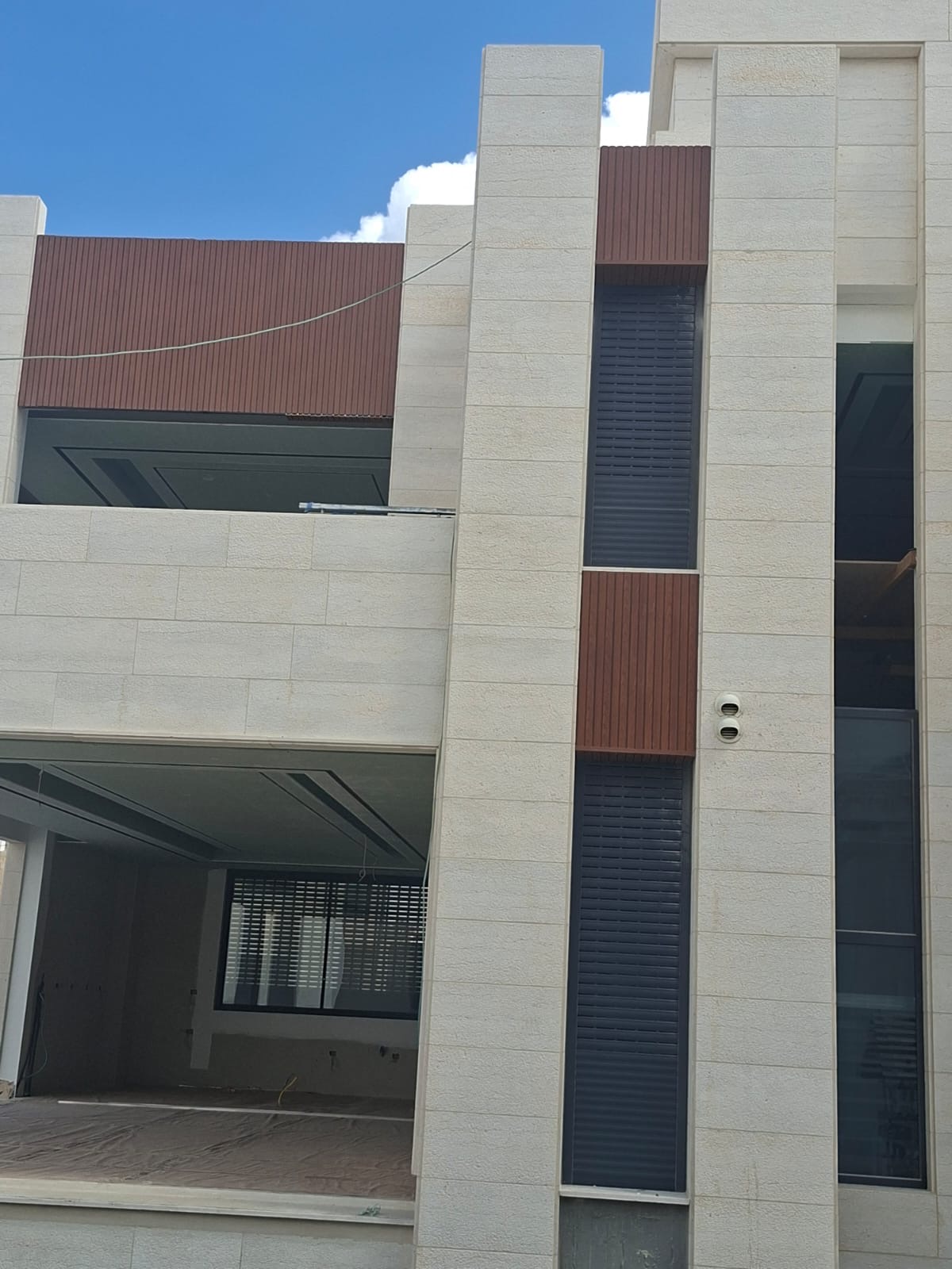 واجهة مبنى حديثة بكسوة حجرية وتفاصيل داكنة