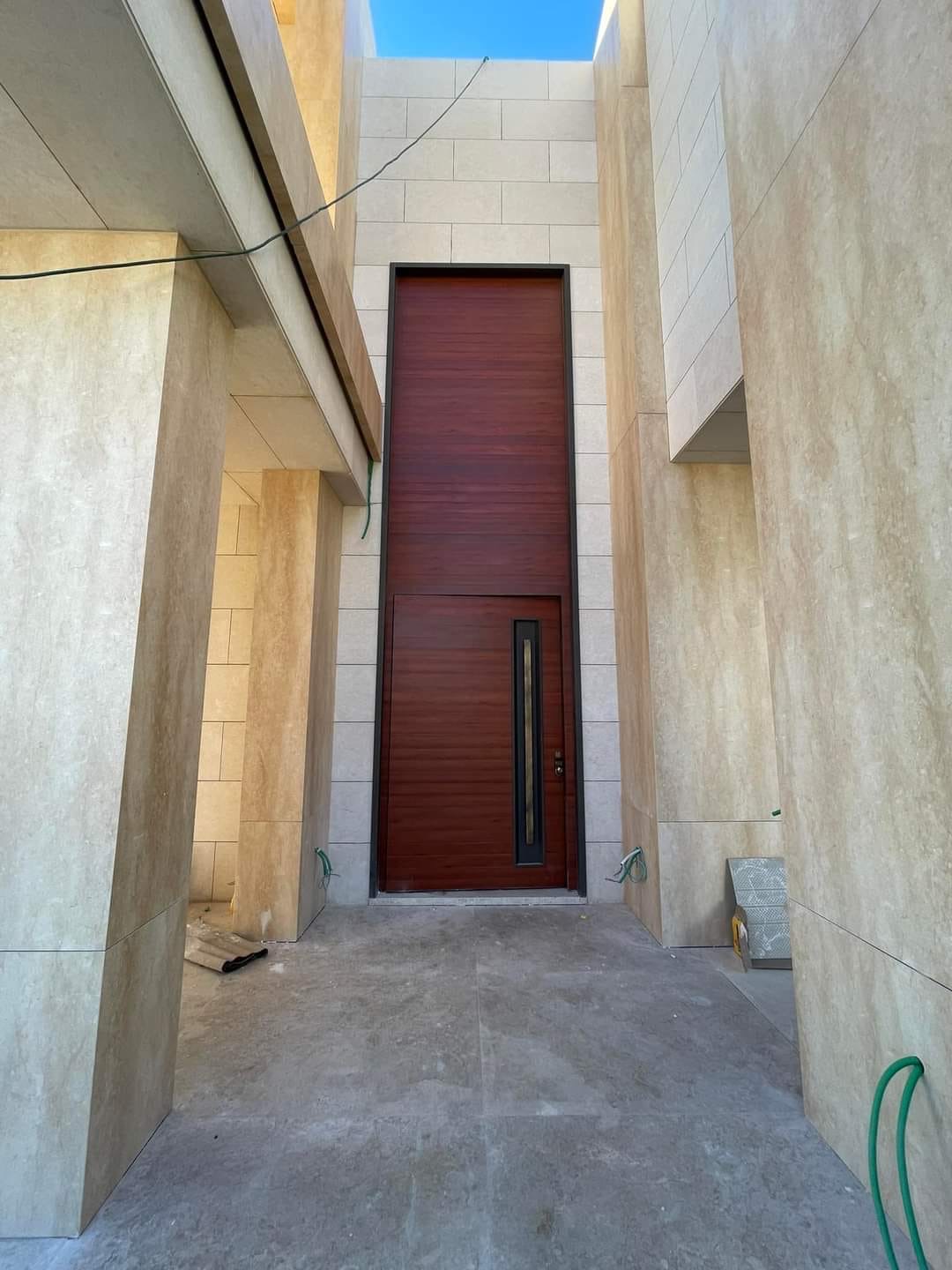 مدخل منزل بكسوة حجرية وباب خشبي